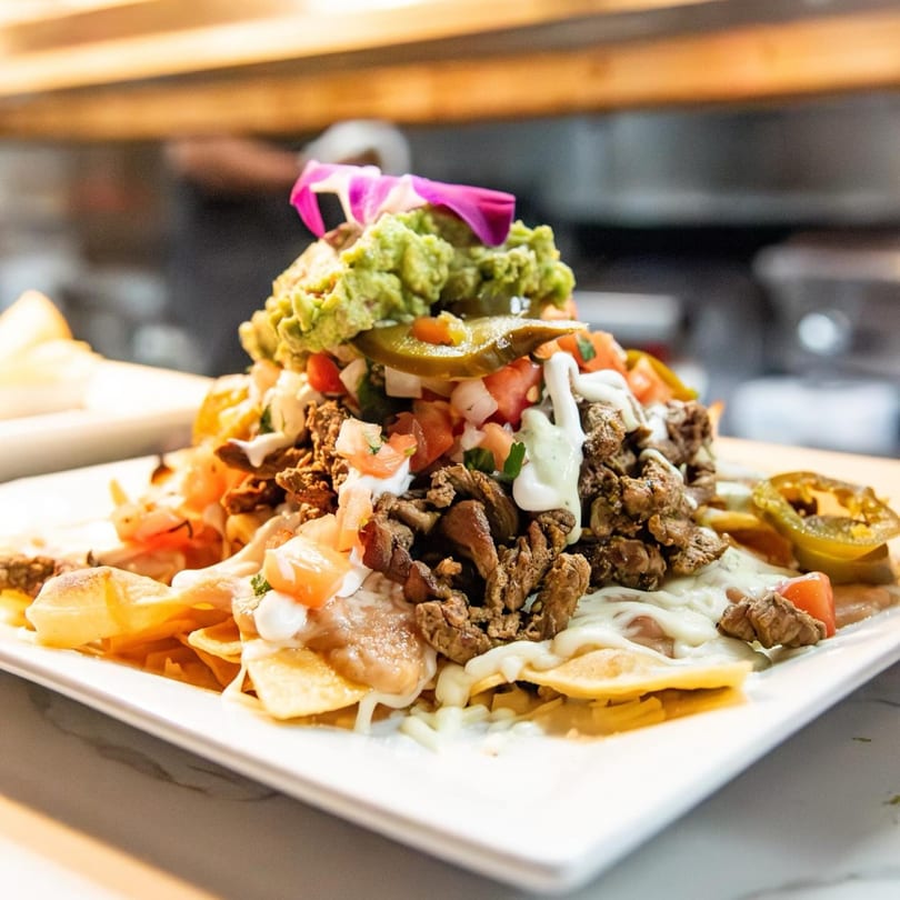 Loaded California Tacos Cantina nachos with steak, guacamole, pico de gallo, and jalapeños.